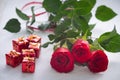 Occasional beautiful red roses with tiny boxes of gifts on the shiny background