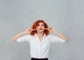 Occlude the ears. Closeup portrait young angry unhappy stressed redhead curly woman covering plugging her ears looking up, stop Royalty Free Stock Photo