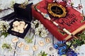 Runes in black box with witch book, magic wand and wildflowers on table Royalty Free Stock Photo