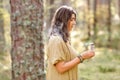 Woman or witch performing magic ritual in forest