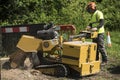 Occupation: Arborist in protective gear uses a stump grinder to remove a tree stump. 6