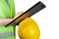 Occupational Safety and Health, inspector in a protective vest with a construction helmet writes with a pen on a clipboard,