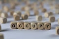 Occupy - cube with letters, sign with wooden cubes