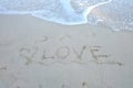 Sea waves on the clean beach with a word of Love on the sand Royalty Free Stock Photo