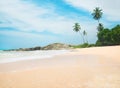 Ocean beach against rock and palms in sunny day Royalty Free Stock Photo