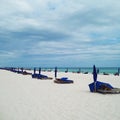 Ocean beach with blue chairs and umbrellas Royalty Free Stock Photo