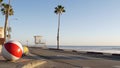 Ocean beach California USA. Ball, lifeguard tower, life guard watchtower hut, beachfront palm tree.