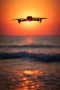 Ocean beach sunrise and flying drone against sun and sea horizon Royalty Free Stock Photo