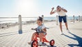 Ocean, bicycle and happy father with girl excited after learning, teaching and helping kid ride bike. Black family, love Royalty Free Stock Photo
