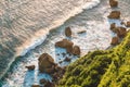 Ocean with big waves, rocks and cliff in Uluwatu at warm sunset