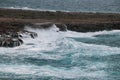 Ocean with blue water during a storm, big waves hitting the rocks on the shore Royalty Free Stock Photo