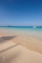 Ocean, boat and blue sky for holiday, sand and rocks in Hawaii for peace and tranquility. Seaside, waves and summer for