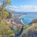 An ocean coast with black beach sand on Puerto de Tazacorte beach from above. Colorful town houses or holiday resort Royalty Free Stock Photo