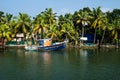 Ocean fishing boat along the canal Kerala backwaters shore with palm trees between Alappuzha and Kollam, India Royalty Free Stock Photo