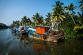 Ocean fishing boats along the canal Kerala backwaters shore with palm trees between Alappuzha and Kollam, India Royalty Free Stock Photo