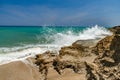 Ocean foamy waves, splashes at the beach near rocks