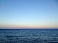 Ocean horizon with clear sky and moon at sunset