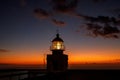 Ocean lighthouse during the sunset. Dramatic clouds on the background. Royalty Free Stock Photo