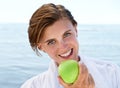 Ocean, portrait and happy woman eating apple for healthy food, diet and wellness in outdoor morning. Fruit, smile and