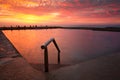 Ocean rock pool under blazing red sky