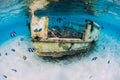 Ocean scene with wreck of boat at sandy bottom and school of fish, underwater in Mauritius Royalty Free Stock Photo