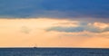 Ocean scenery. Sunset and Virgin nature landscape. Beautiful golden sky. Calming water. Floating boat on horizon. Royalty Free Stock Photo