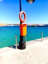 Ocean shore, pier, orange life buoy Royalty Free Stock Photo