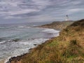 An ocean shore and Waipapa Point lighthouse in the Catlins area of the South Island of New Zealand