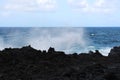 Ocean spray rising from the Pacific Ocean over jagged, black, volcanic rock at Waianapanapa State Park Royalty Free Stock Photo