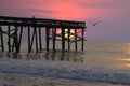 An enhance sunrise shines through the beach fishing pier on Amelia Island