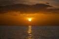 Ocean sunset. Big white sun on dramatic bright sky background, soft evening horizont over sea dark water Royalty Free Stock Photo