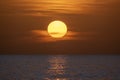 Ocean sunset. Big white sun on dramatic bright sky background, soft evening horizont over sea dark water Royalty Free Stock Photo