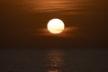 Ocean sunset. Big white sun on dramatic bright sky background, soft evening horizont over sea dark water Royalty Free Stock Photo