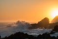 Ocean sunset with wave breaking onto silhouette rocks. Royalty Free Stock Photo