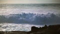 Ocean surf crashing coast on sunny day. Extreme stormy waves splashing rocky