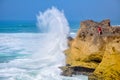 Huge waves are breaking about the rocky coast of the Atlantic Ocean, on the shore fishermen Royalty Free Stock Photo