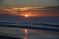 The ocean surface begins to light up in a deep blue color as the sun rises