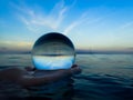 Ocean Surface Reflection in Glass Ball Held in Hand in Water Royalty Free Stock Photo