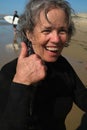 Ocean surfing athletic excited senior woman gray hair