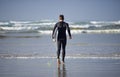 Ocean, surfing and man with surfboard at beach for waves on summer vacation, weekend and holiday by sea. Travel, nature Royalty Free Stock Photo