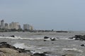 The ocean tides reaching towards the shoreline, in the background a small harbor