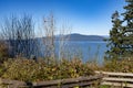 Ocean scene, primitive fence, shrubs and tree in the fall, island and blue sky