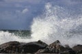 Ocean water splash on rock beach with beautiful sky and clouds. Sea wave splashing on stone at sea shore. Royalty Free Stock Photo