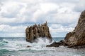 Ocean water splash on rock beach with beautiful sky and clouds. Sea wave splashing on stone at sea shore on winter. Sea waves lash Royalty Free Stock Photo