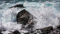 Ocean wave breaking on rocks in the water and splashing onto it, Madeira, Portugal Royalty Free Stock Photo