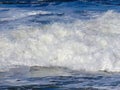 Ocean wave breaking with white foam and blue water Royalty Free Stock Photo