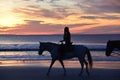 The color of sunrise envelopes a small group of horseback riders Royalty Free Stock Photo