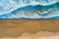 Ocean waves crash into the shore at sunset.