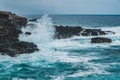 Ocean Waves Crashing Against Black Rocks On Coast