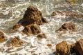 Ocean waves crashing on rocks on coastline at high tide